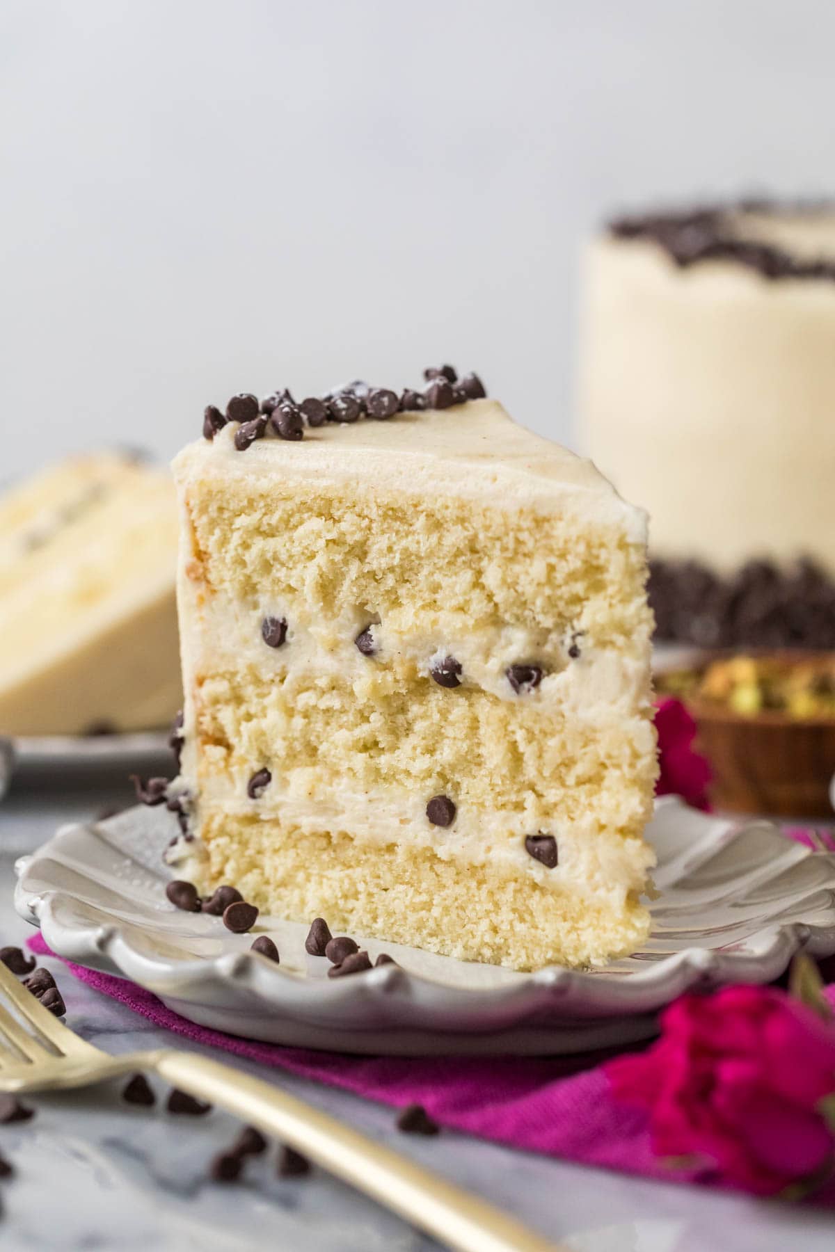 Slice of cannoli cake standing on a white plate.