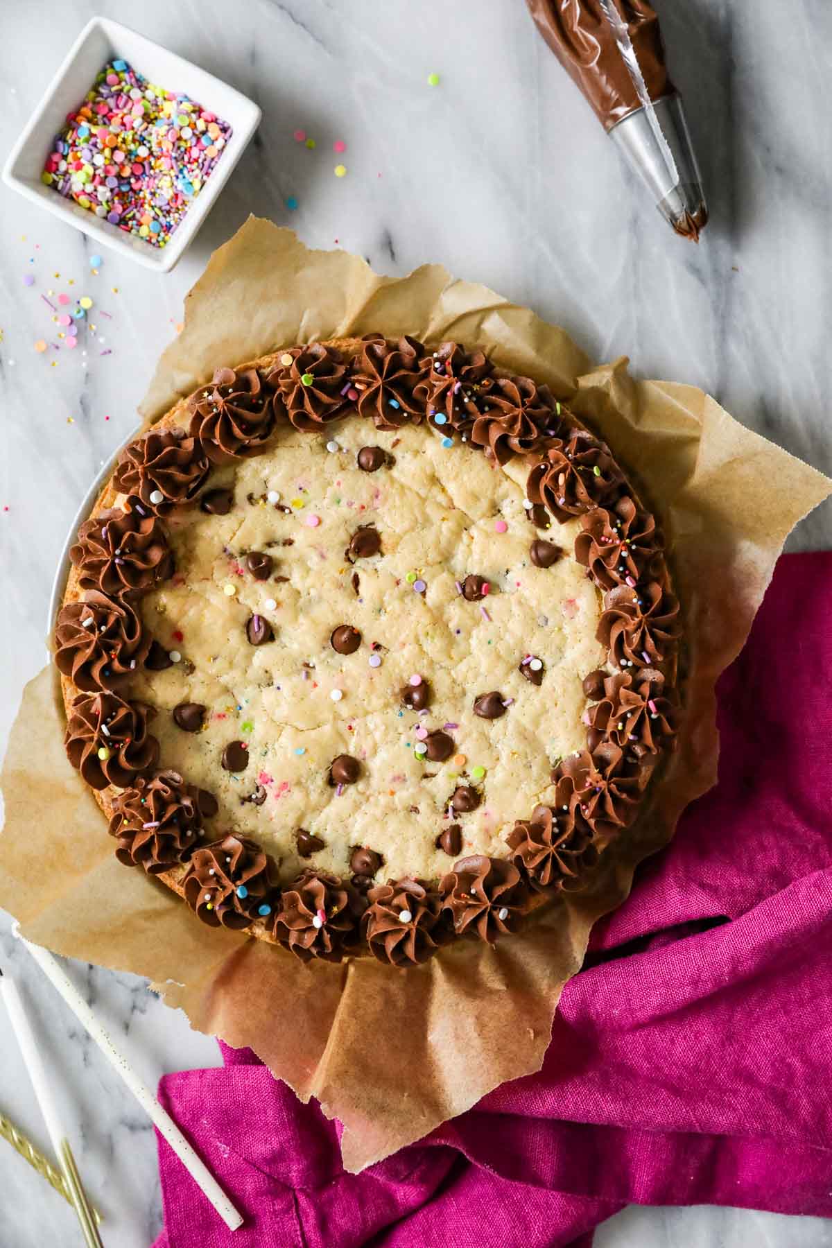 Overhead view of a cookie cake topped with a ring of chocolate frosting.