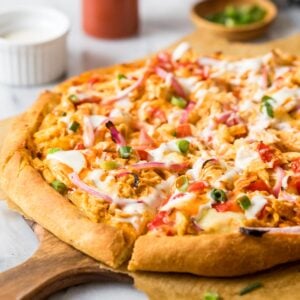 Homemade buffalo chicken on a wood serving platter.