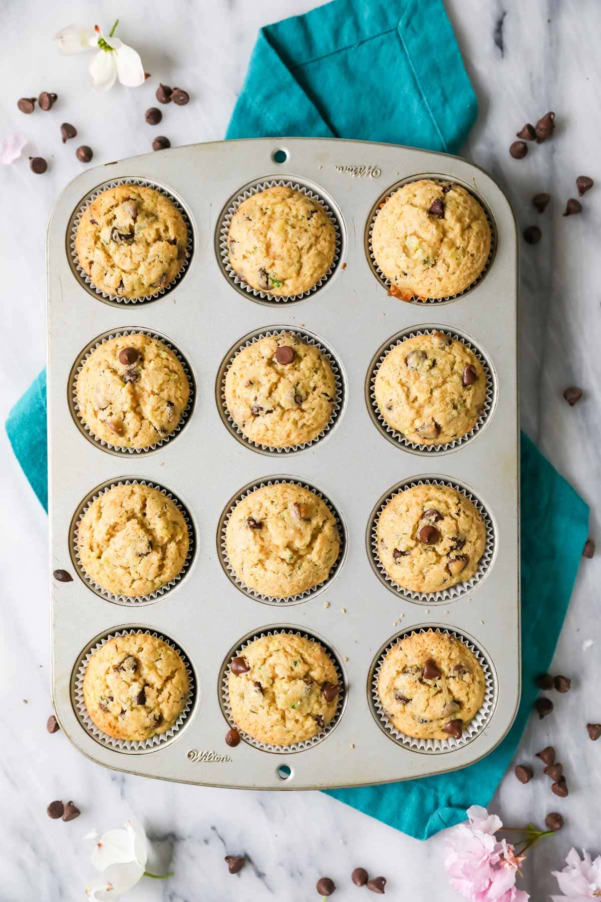 Overhead view of a pan of zucchini muffins made with chocolate chips.