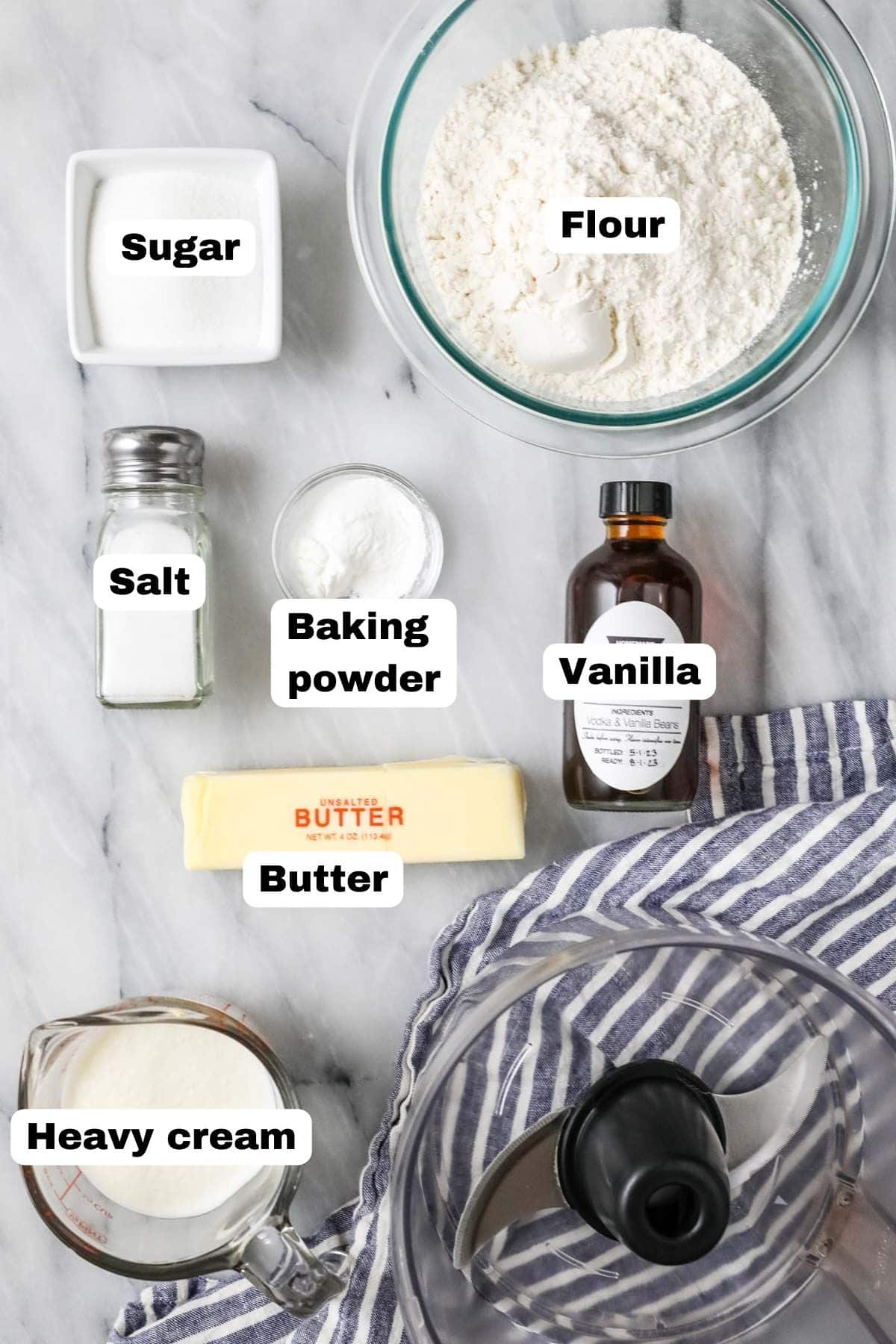 Overhead view of labeled ingredients including flour, butter, heavy cream, and more.