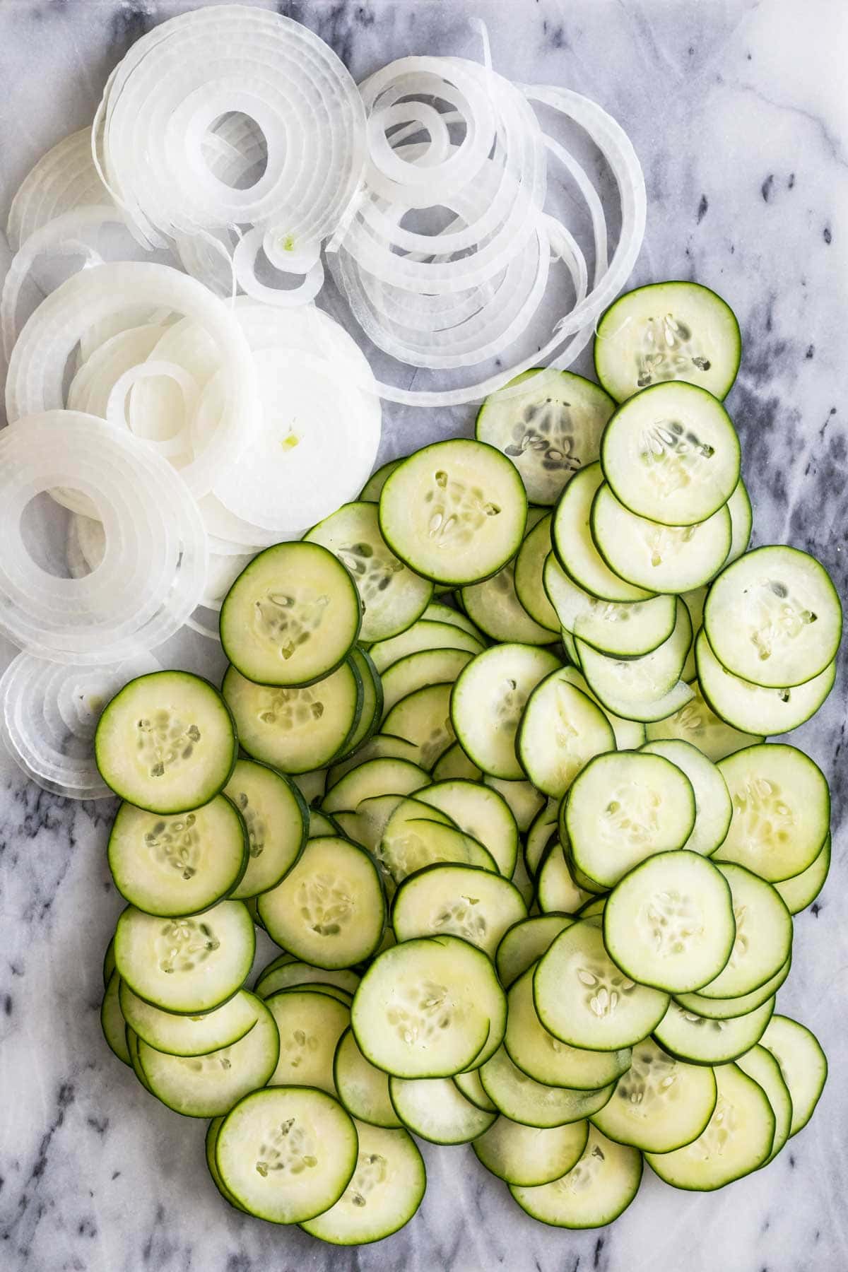 Overhead view of sliced cucumbers and onions.