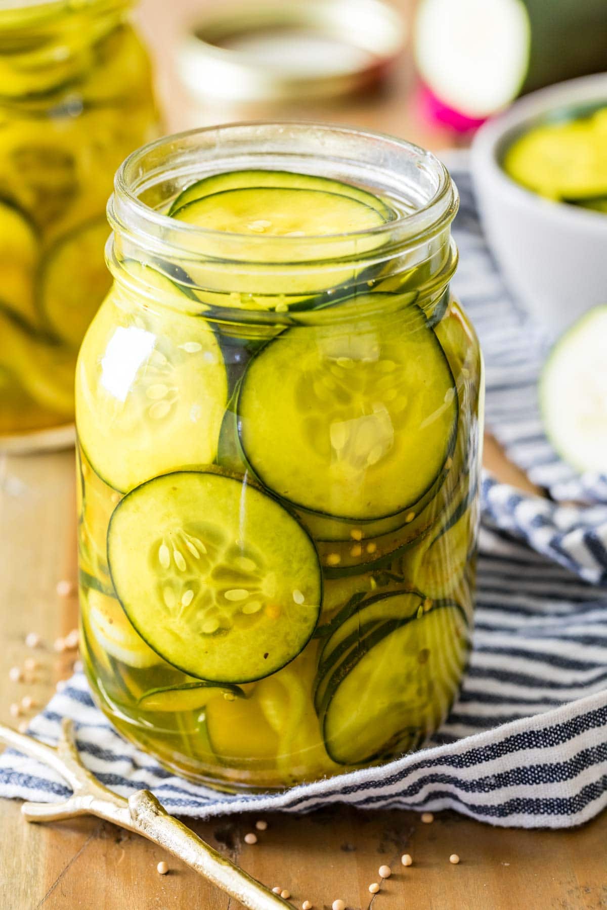 Jar of refrigerator pickles on a striped towel.