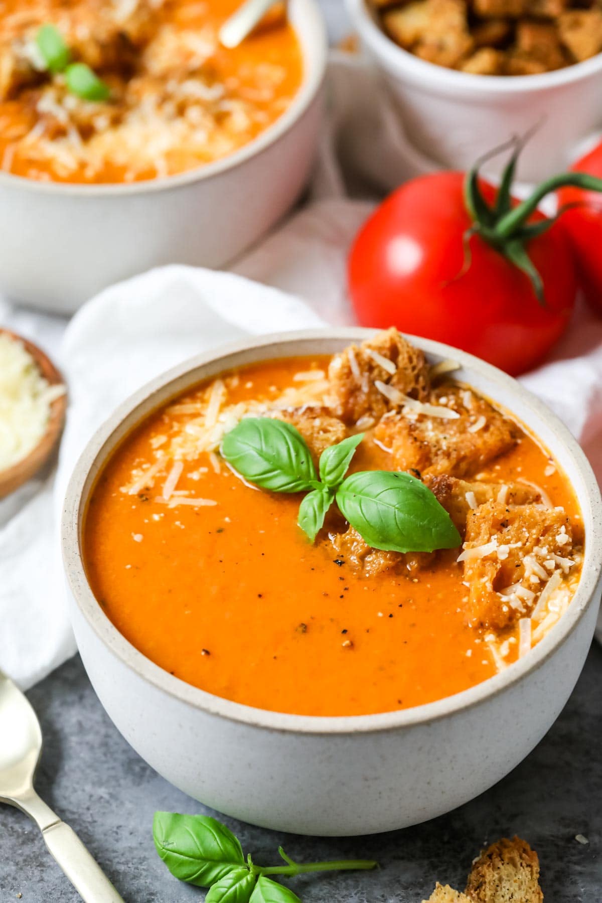 Overhead view of a bowl of tomato basil soup made with fresh tomatoes and basil.