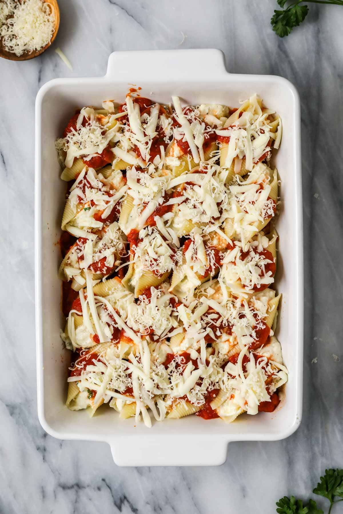 Overhead view of a pan of stuffed shells before baking.