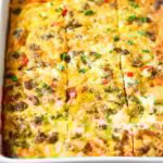 Close-up view of a breakfast casserole that's been cut into squares.