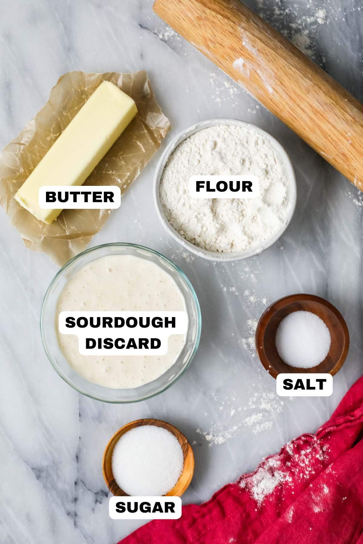 Overhead view of labeled ingredients including sourdough discard, flour, butter, and more.