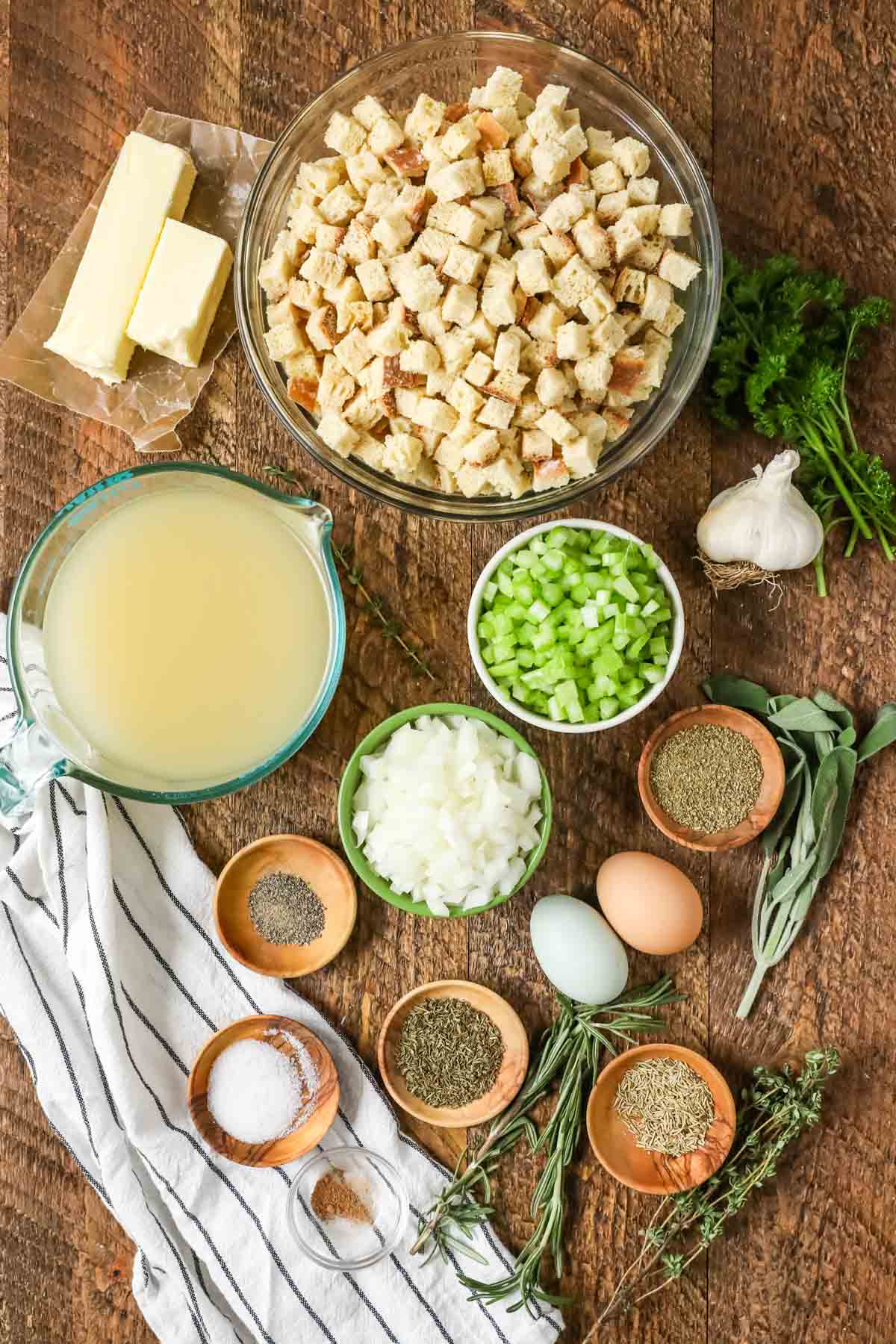 Overhead view of ingredients including celery, onions, bread cubes, fresh herbs, and more.