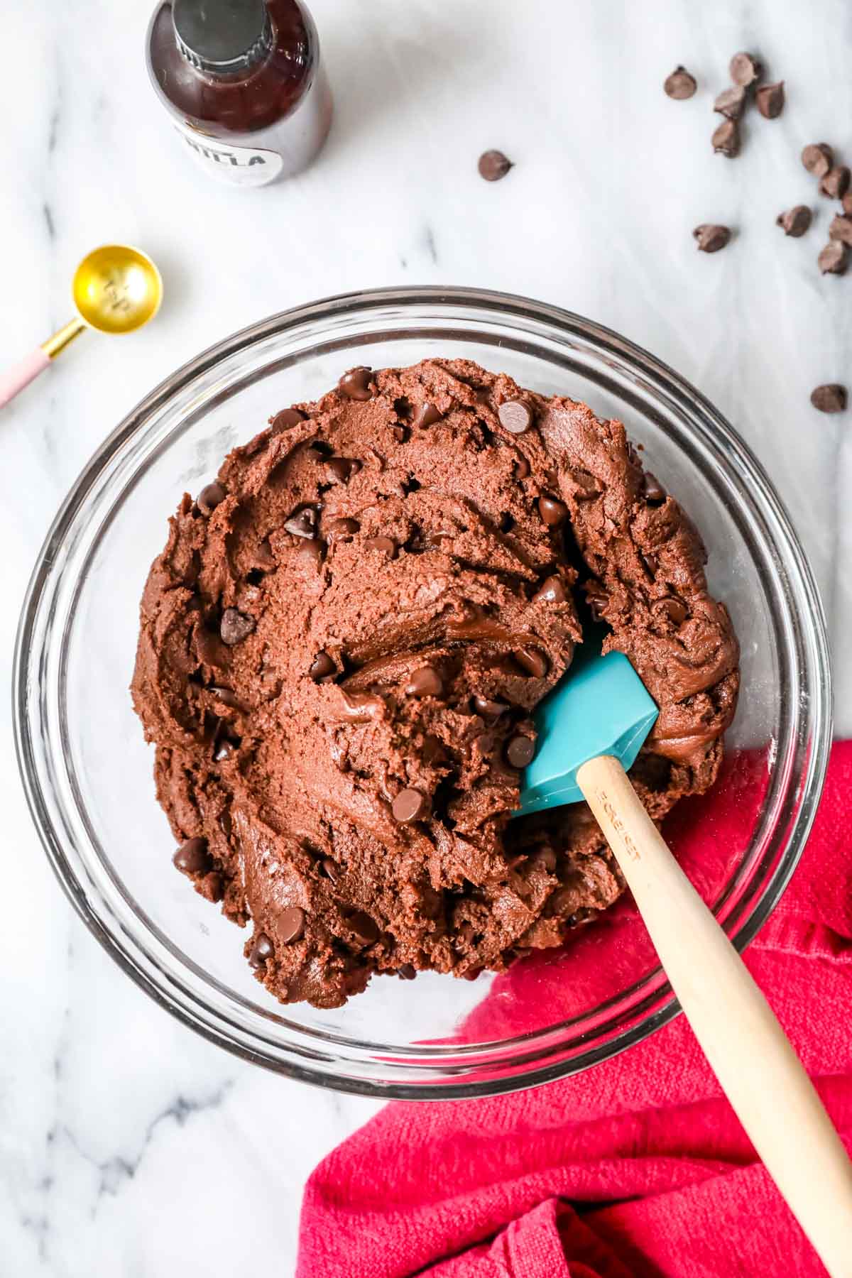 Overhead view of a bowl of chocolate cookie dough with chocolate chips.