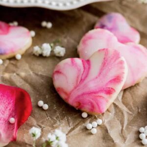 Swirled heart cookies surrounded by baby's breath on parchment paper.