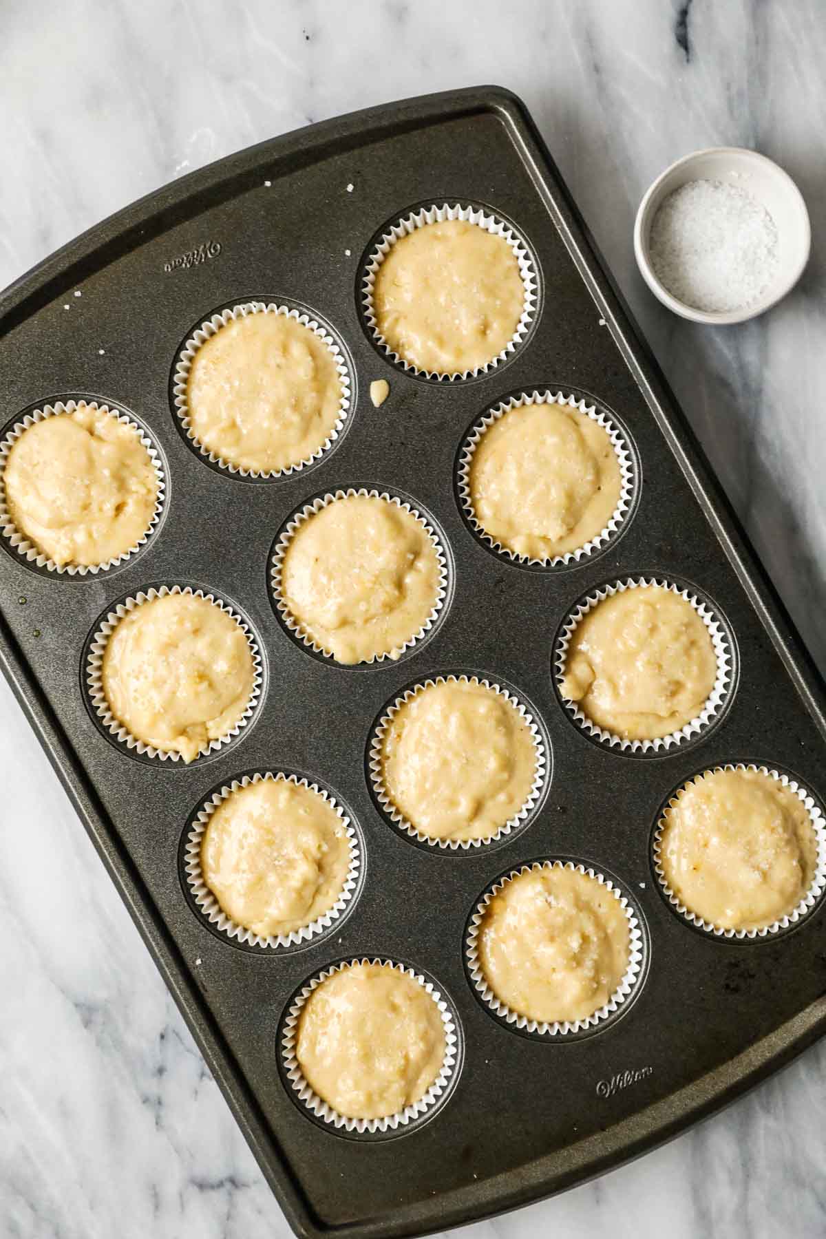 Overhead view of a pan of sourdough muffins before baking.