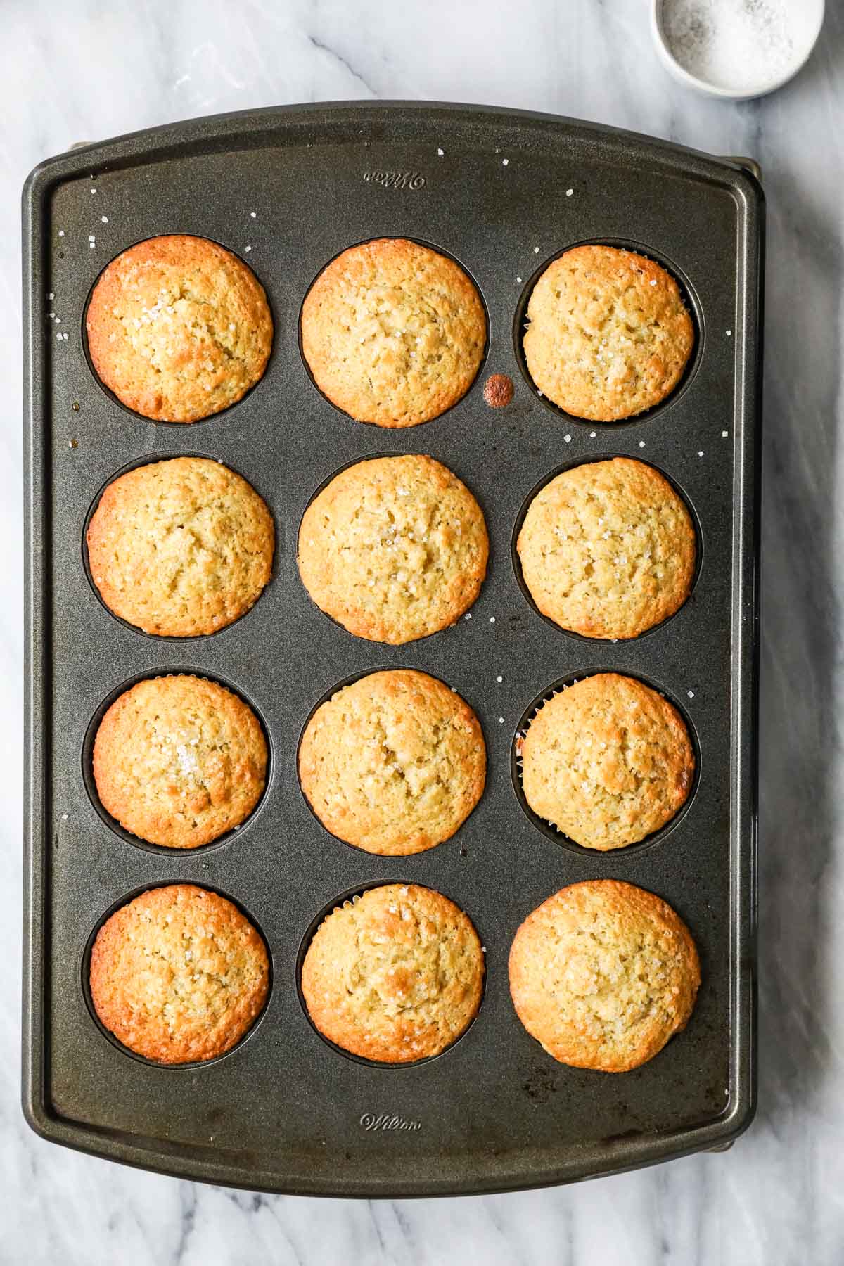 Overhead view of a pan of sourdough muffins after baking.