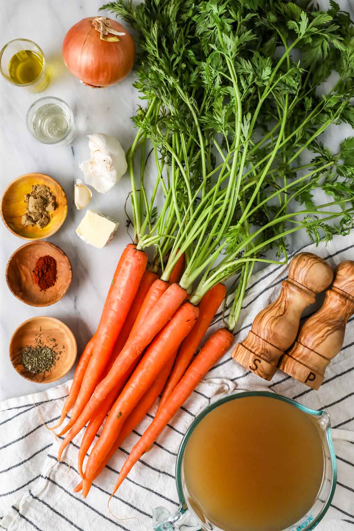 Overhead view of ingredient including carrots, broth, spices, and more.