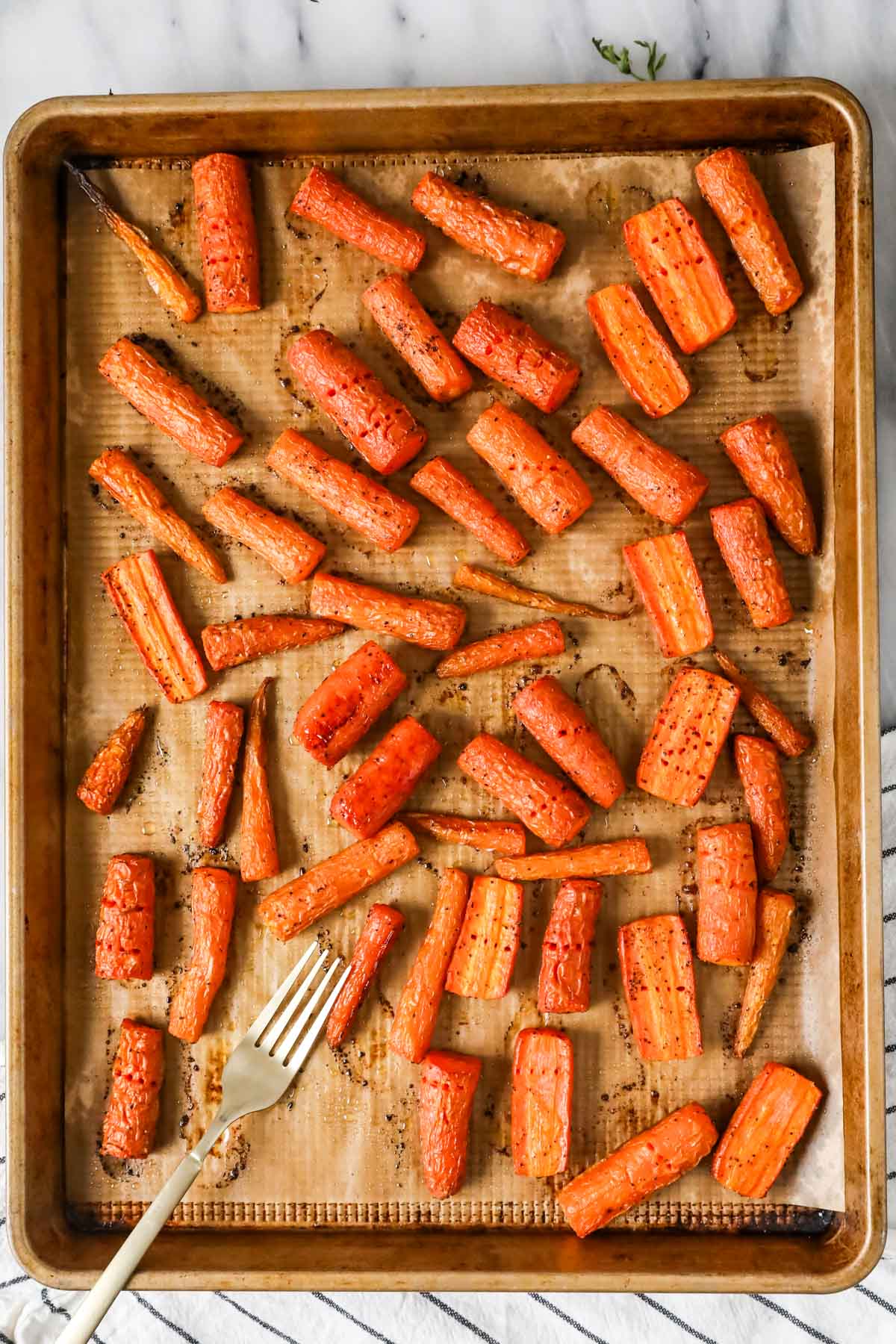 Overhead view of chopped carrots on a roasting pan.