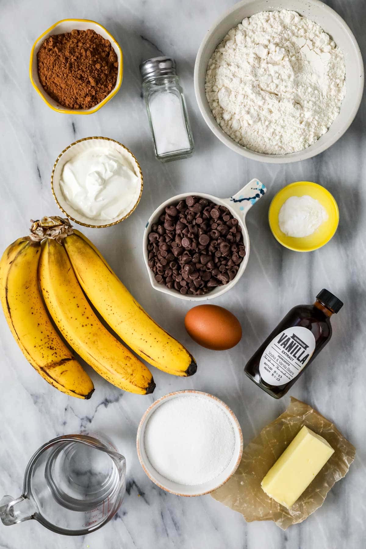 Overhead view of ingredients including bananas, chocolate chips, cocoa powder, and more.