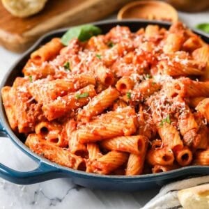 Skillet of homemade rigatoni topped with freshly grated parmesan cheese.