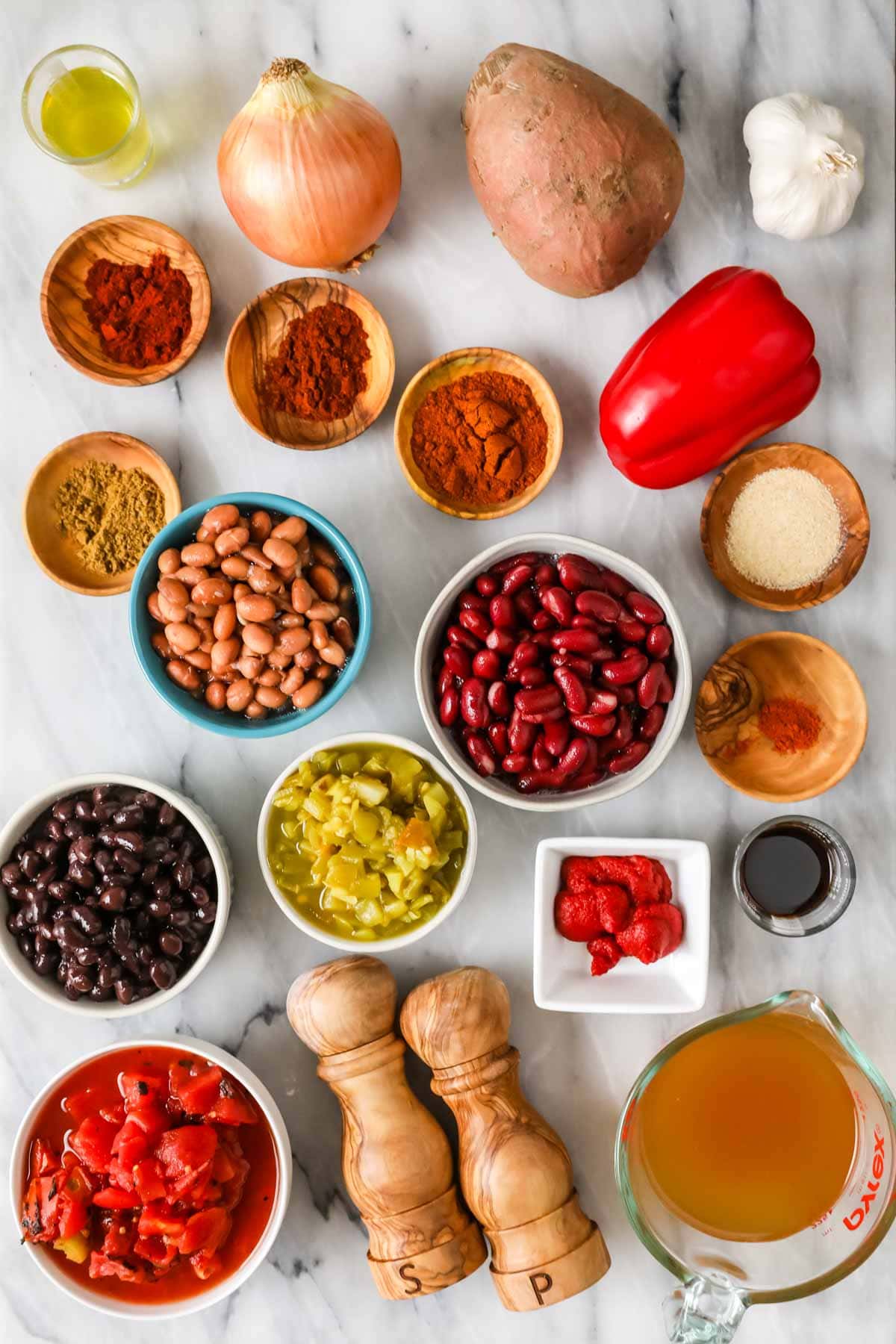 Overhead view of ingredients including sweet potato, beans, green chiles, and more.