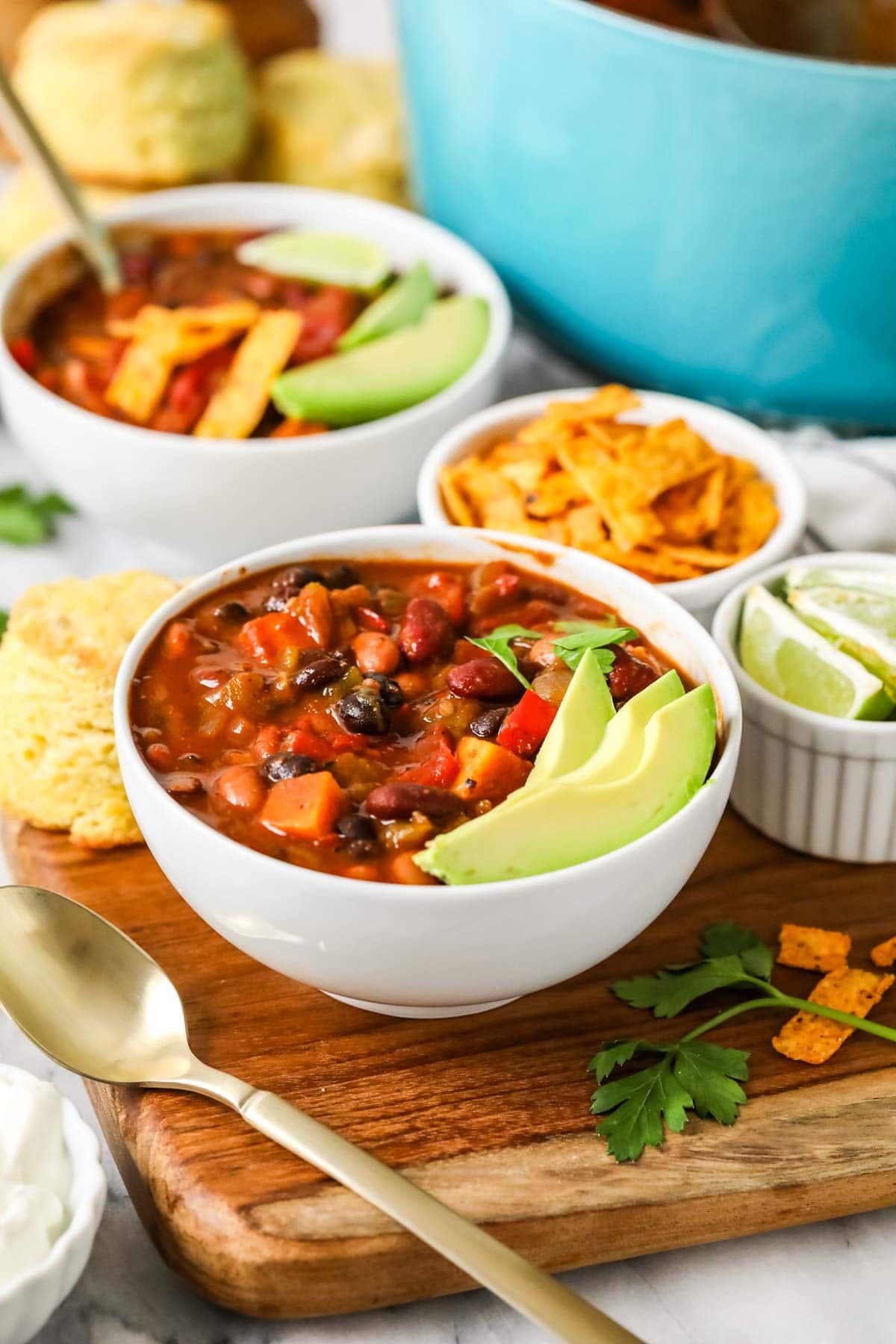 Bowl of vegetarian chili topped with slices of avocado.