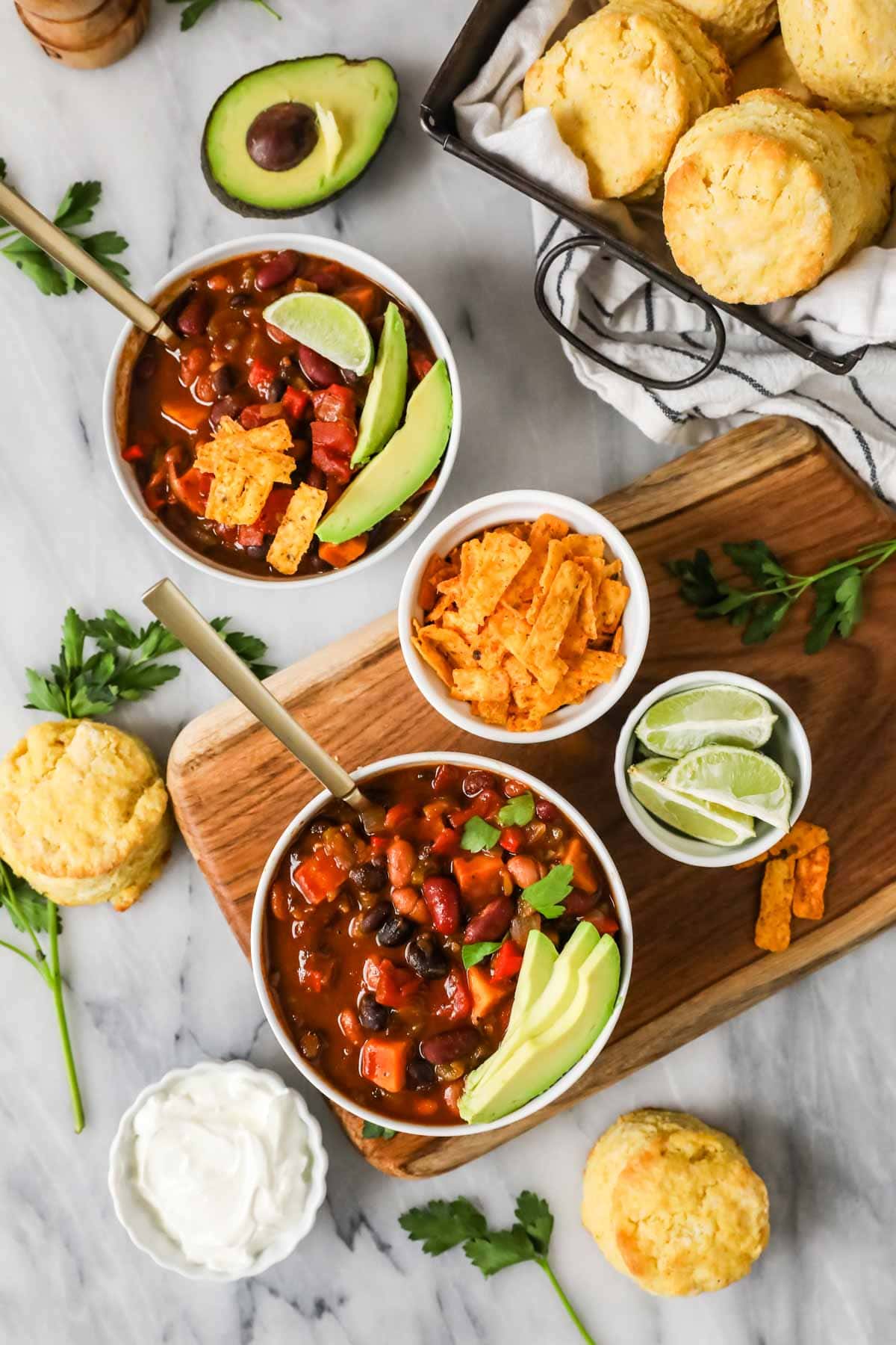Overhead view of bowls of vegetarian chili topped with slices of avocado.
