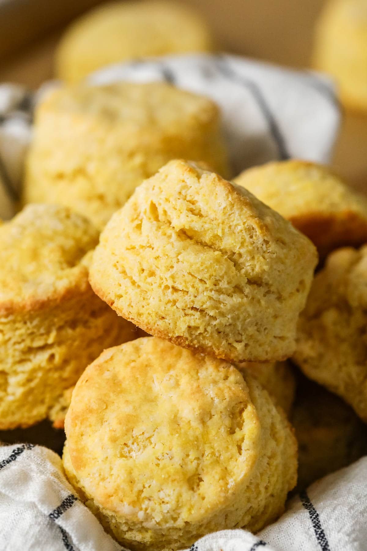 Tall cornbread biscuits with flaky layers in a pile.