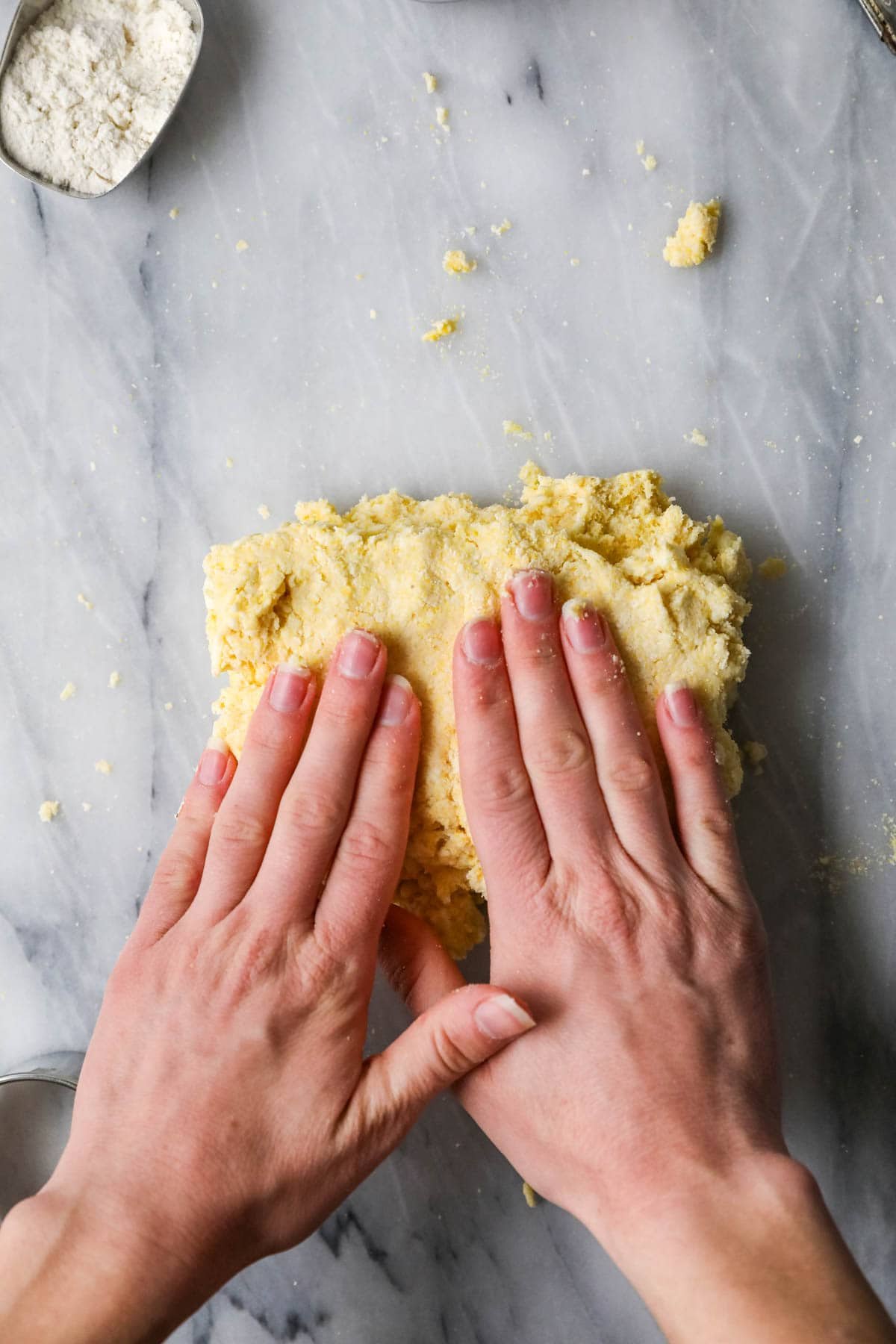 Hands patting a dough after lamination.