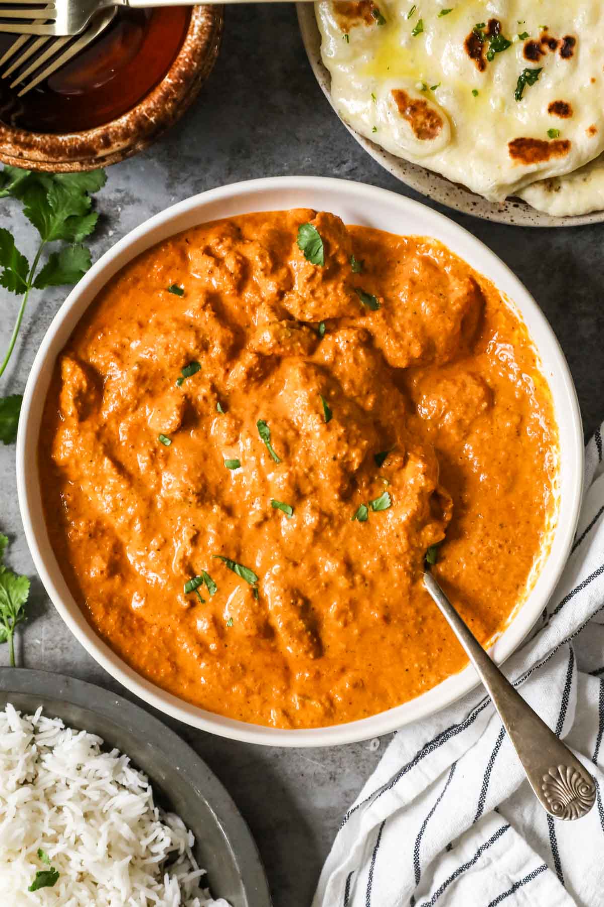 Overhead view of a creamy, tomato-based Indian chicken dish in a bowl.