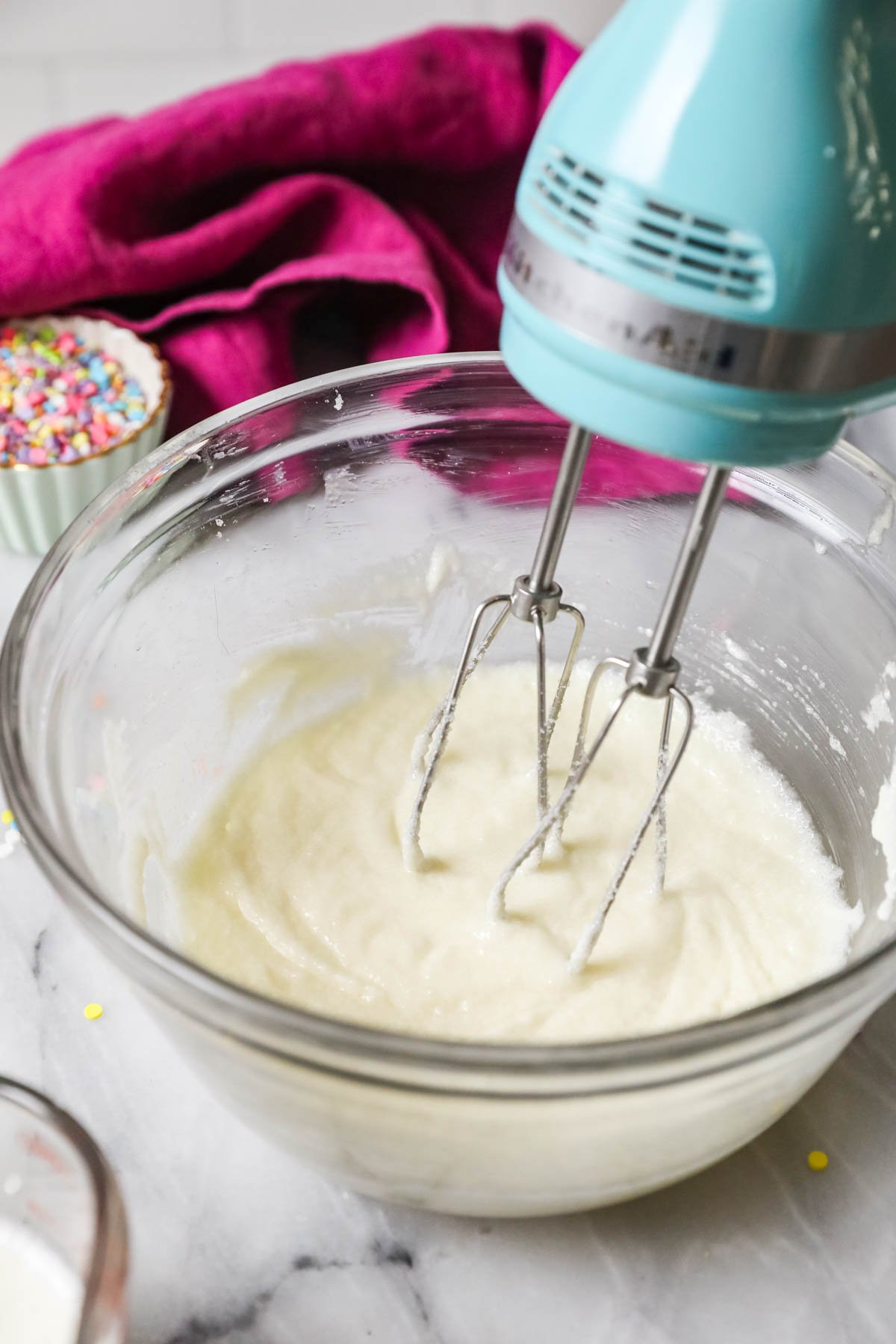 Hand mixer mixing fats and sugar until creamy.