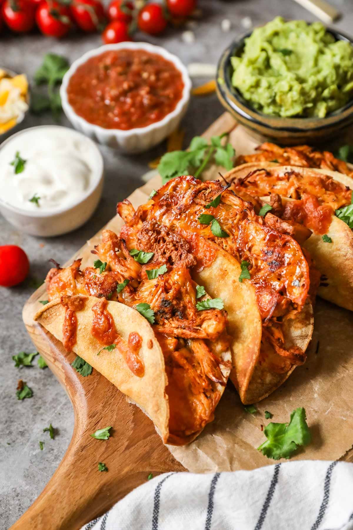 Crispy chicken tacos on a wood cutting board. 