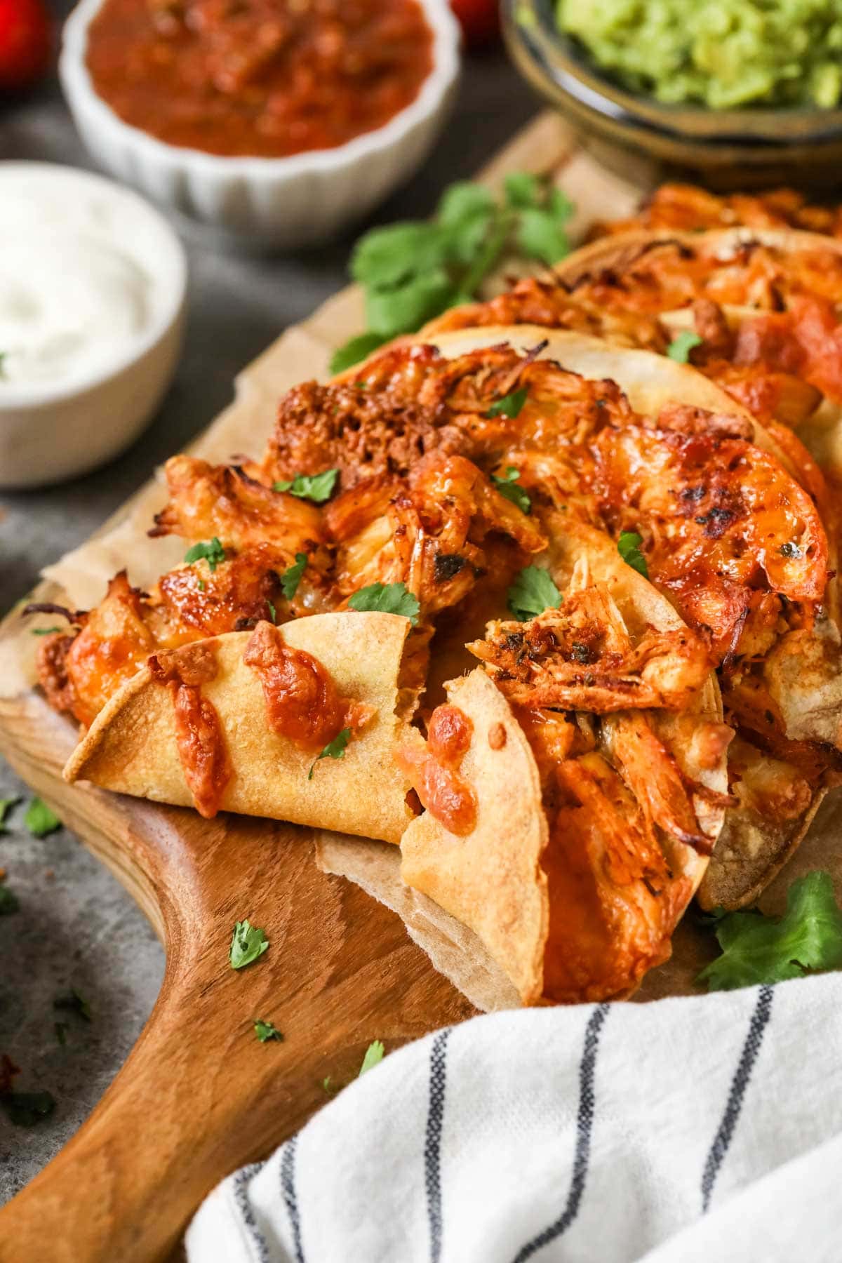 Crispy chicken tacos on a wood cutting board.