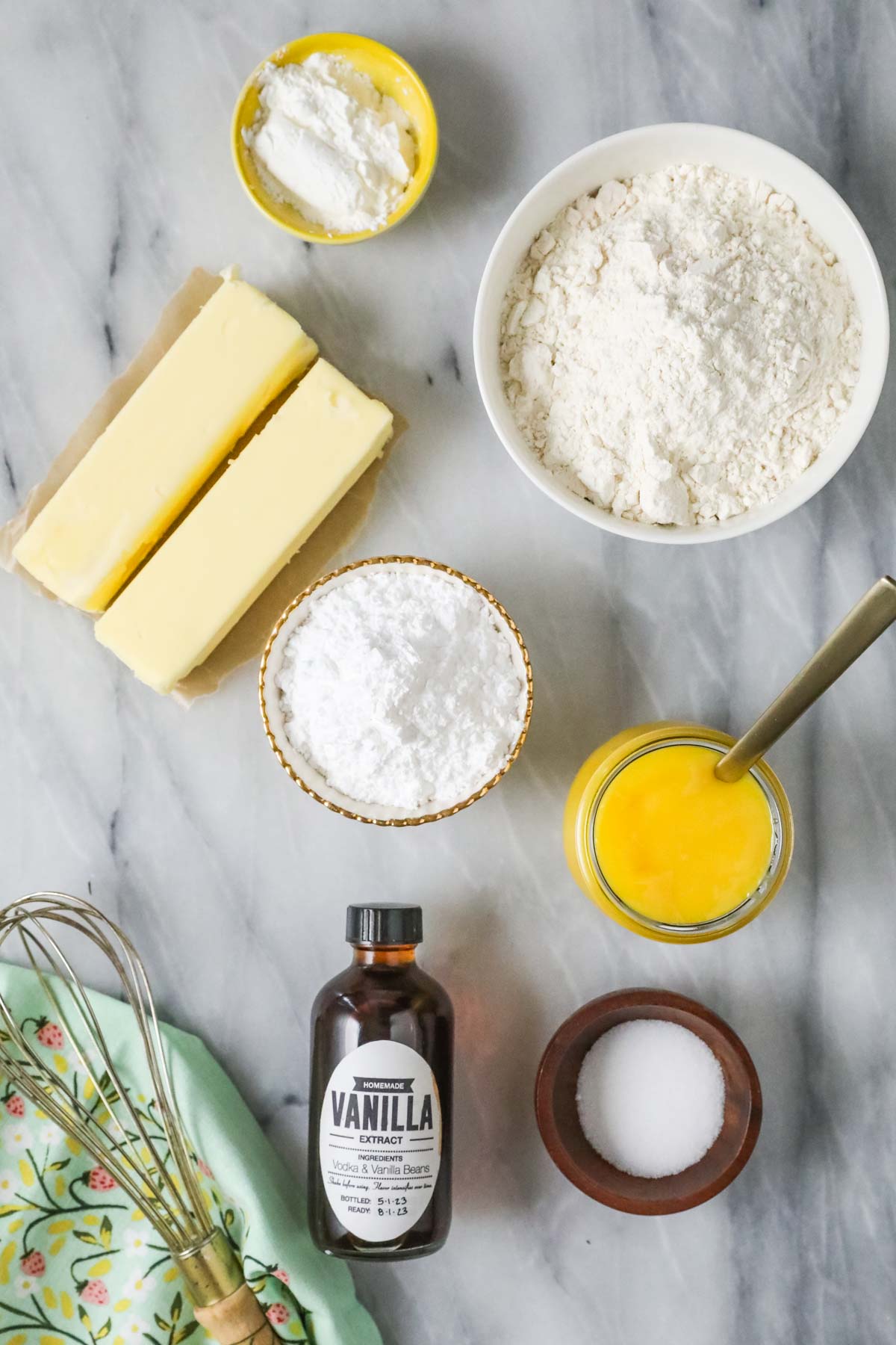 Overhead view of ingredients including butter, lemon curd, powdered sugar, and more.