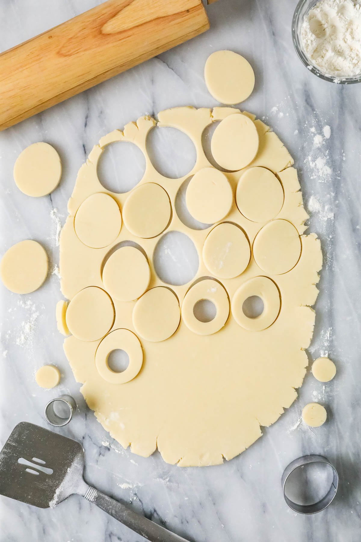 Overhead view of a rolled out cookie dough that's been cut with an egg shaped cookie cutter.
