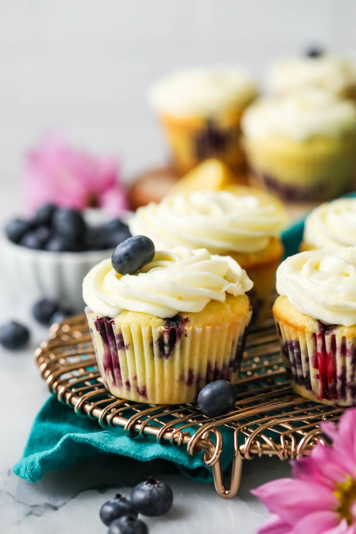 Lemon blueberry cupcakes on a cooling rack.