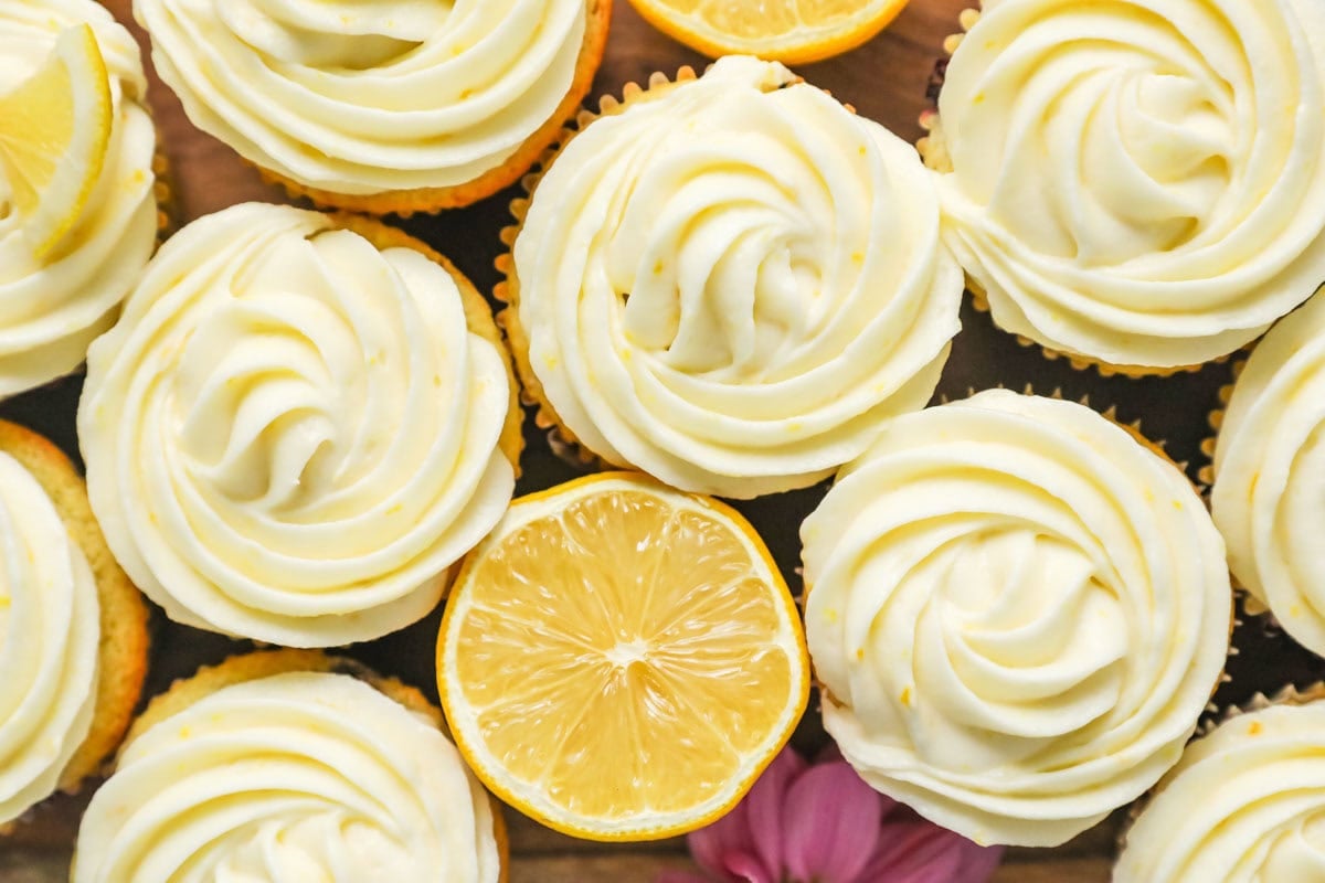 Close-up overhead view of cupcakes topped with swirls of frosting made with cream cheese and lemon.