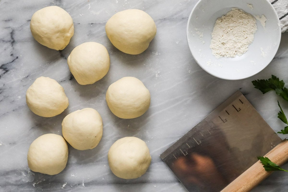 Overhead view of eight balls of dough in rows.