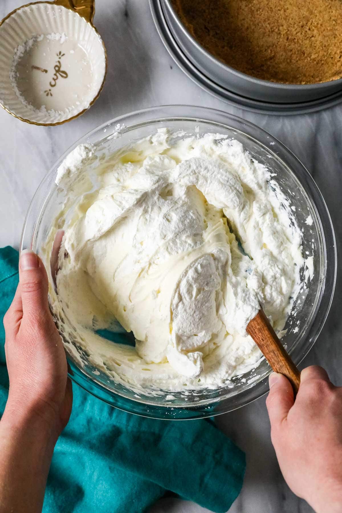 Overhead view of whipped cream being folded into a cream cheese mixture.