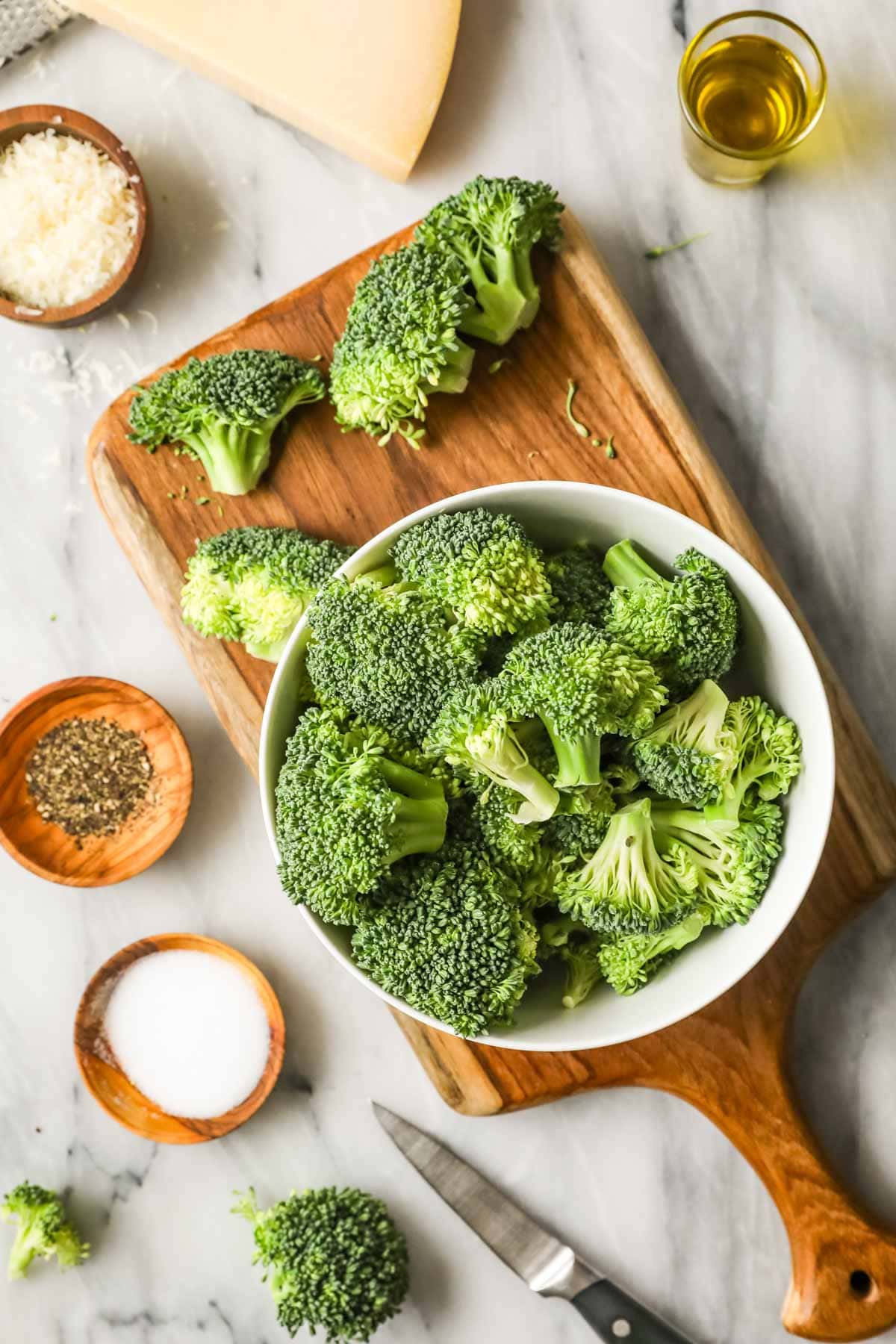 Overhead view of ingredients including broccoli, spices, cheese, and oil.