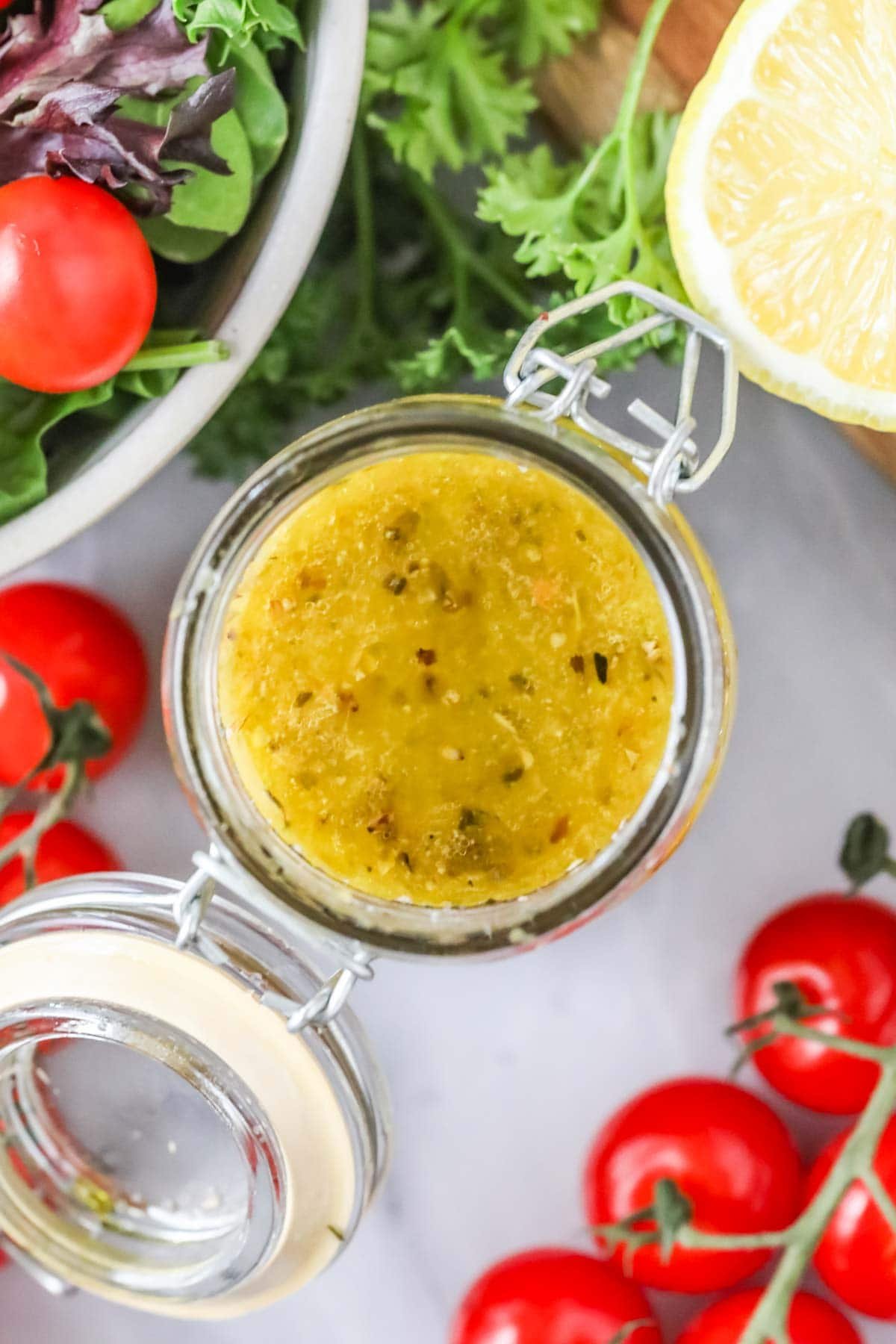 Overhead view of a jar of homemade dressing made with oregano, basil, parmesan, and more.