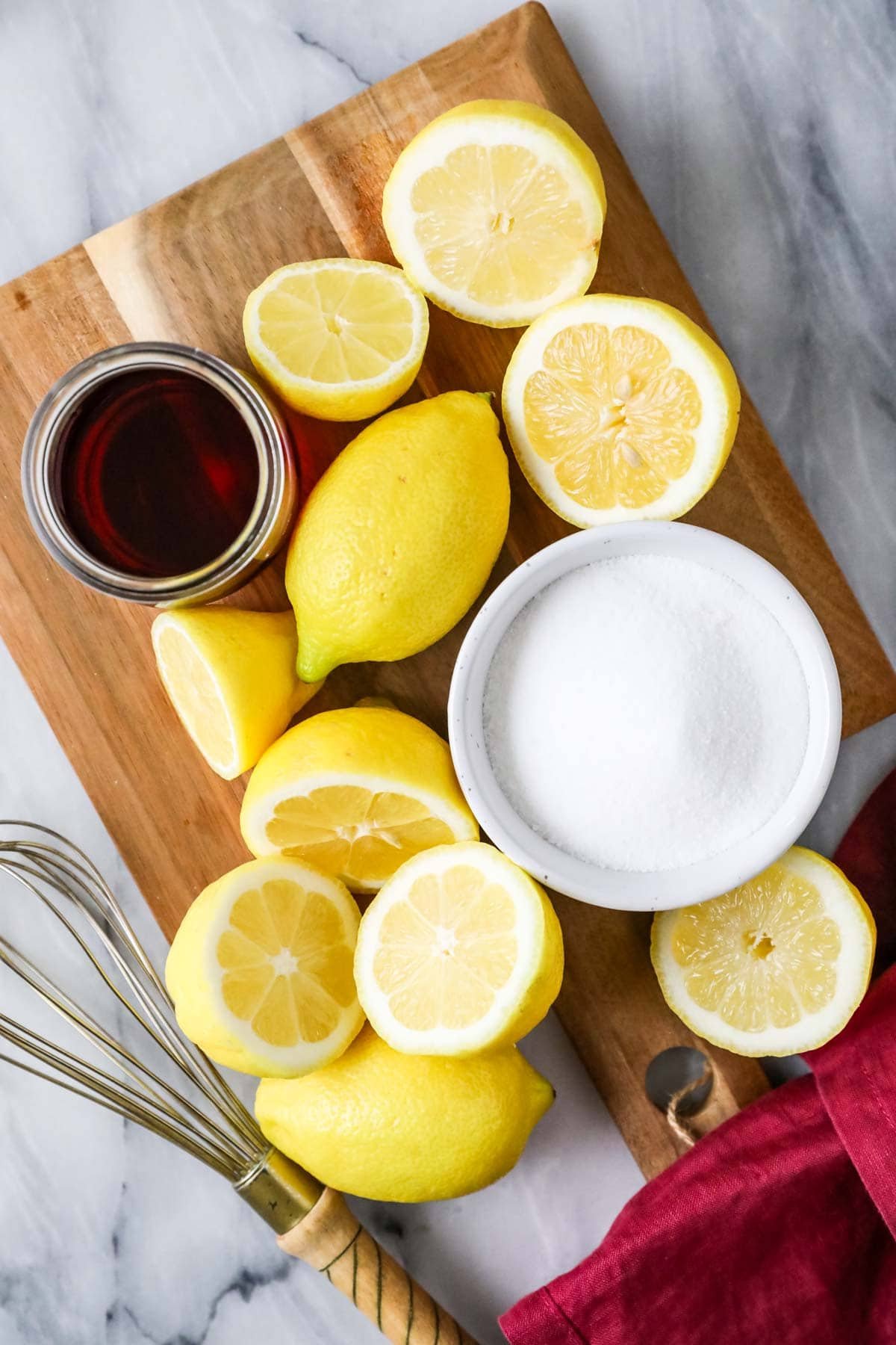 Overhead view of ingredients including lemons, sugar, and cranberry juice.