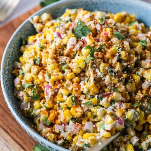 Overhead view of a bowl of Mexican street corn salad in a blue serving bowl.