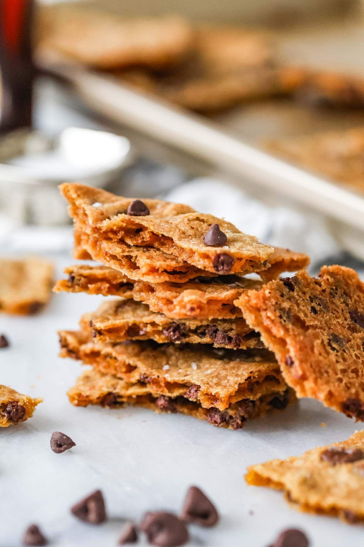 Stacked layers of a thin cookie candy hybrid made with chocolate chips.