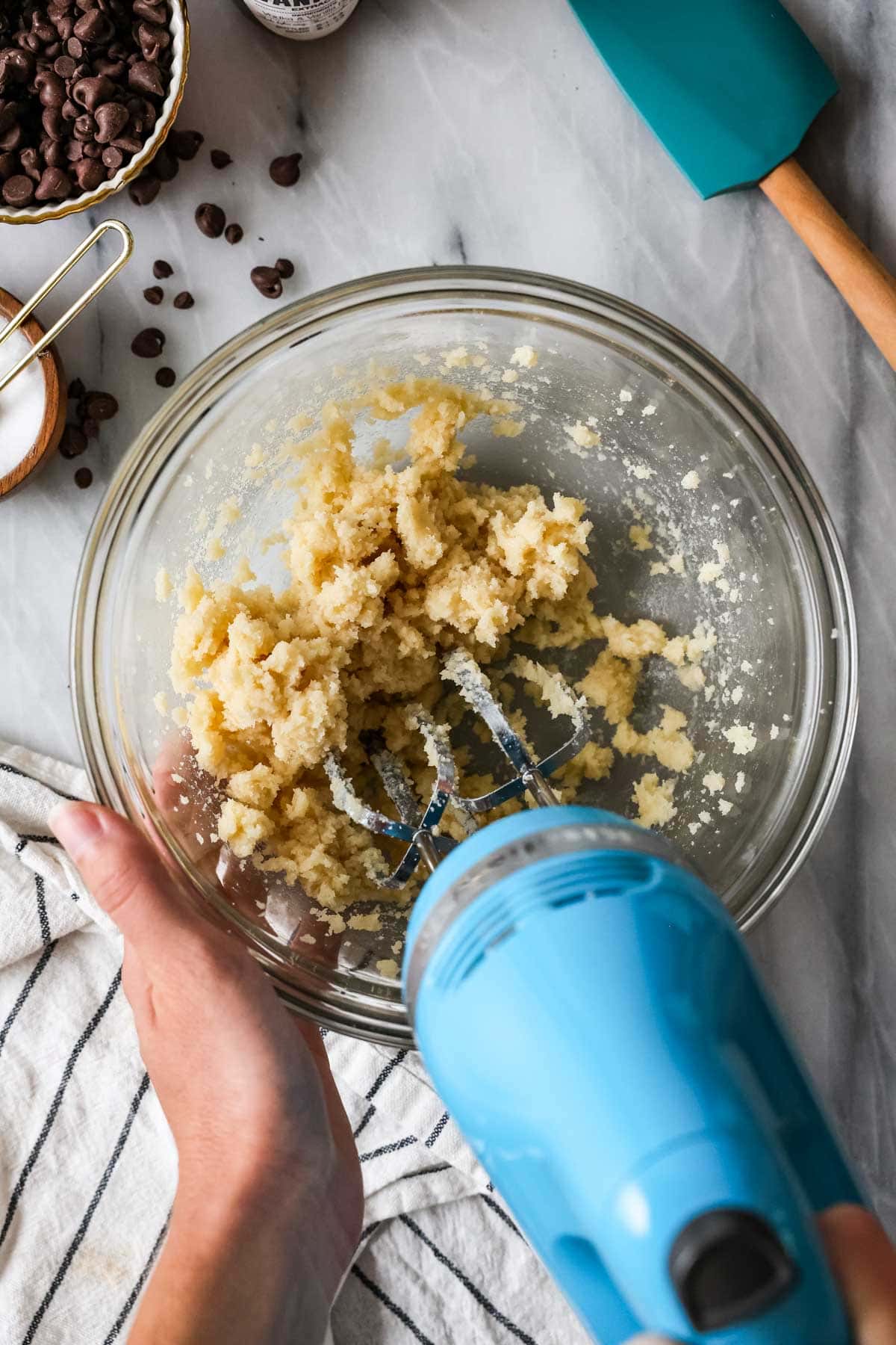 Overhead view of butter and sugar being creamed with an electric mixer.