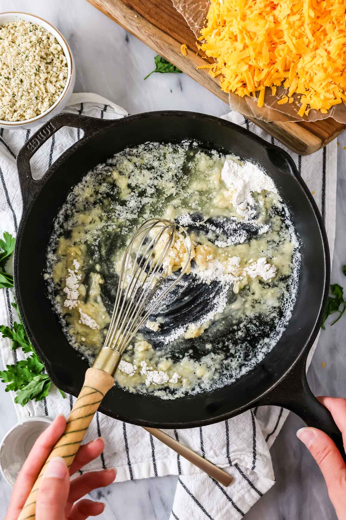 Stirring flour and spices into melted butter to make a roux for mac and cheese.