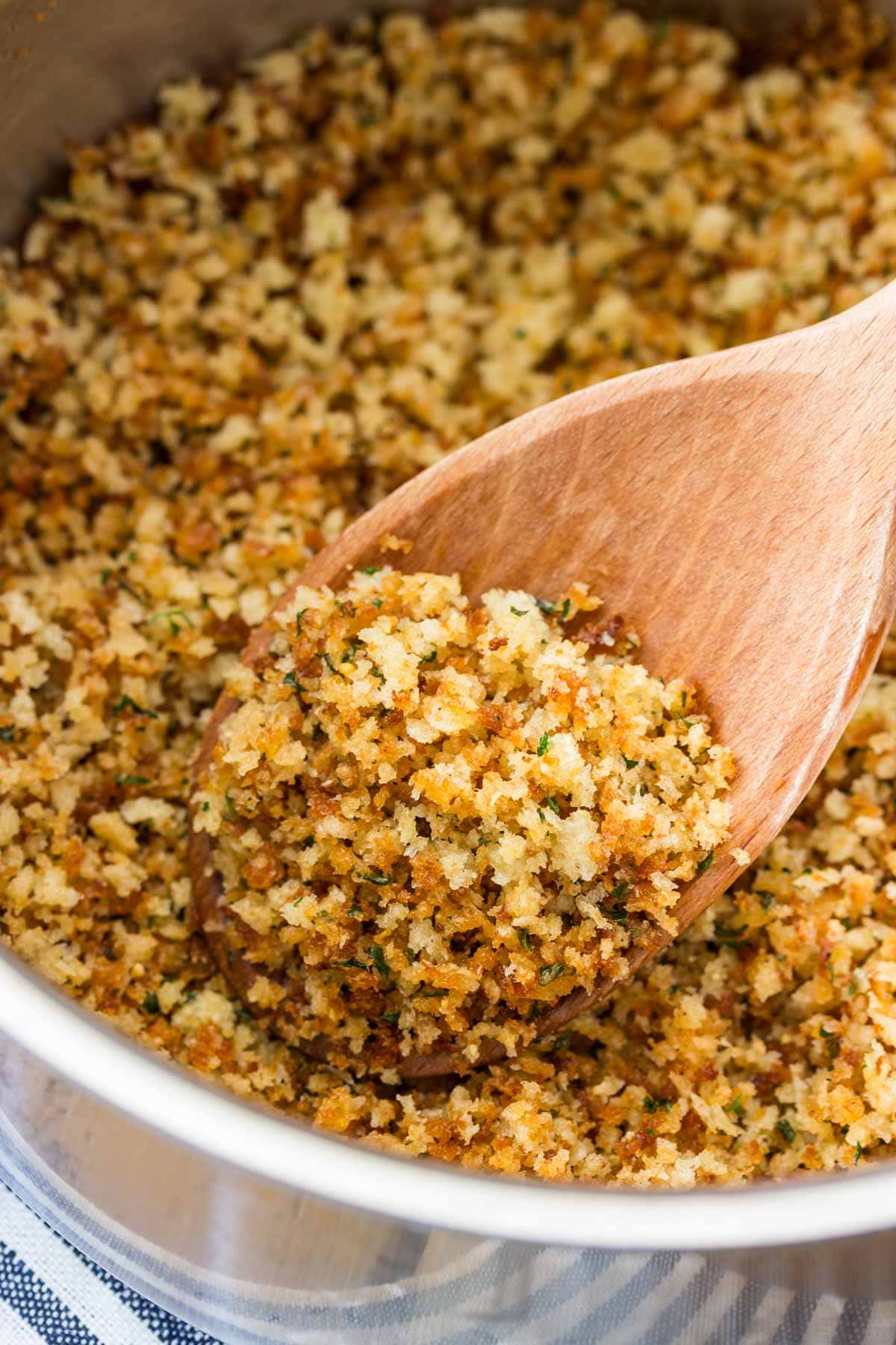 crispy toasted panko in a saucepan with a wooden spoon.