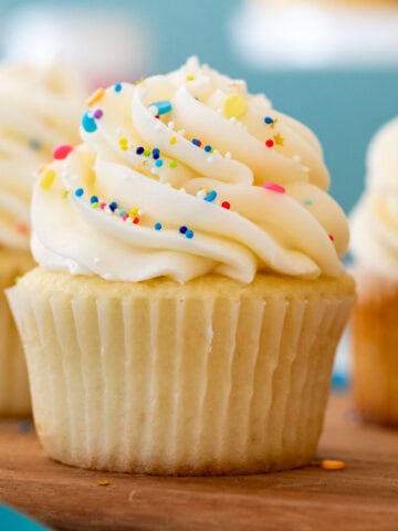 Head-on view of a cupcake frosted with buttercream frosting and sprinkles.