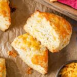 Overhead view of wedge shaped cheese scones with the top scone on its side to show flaky layers.
