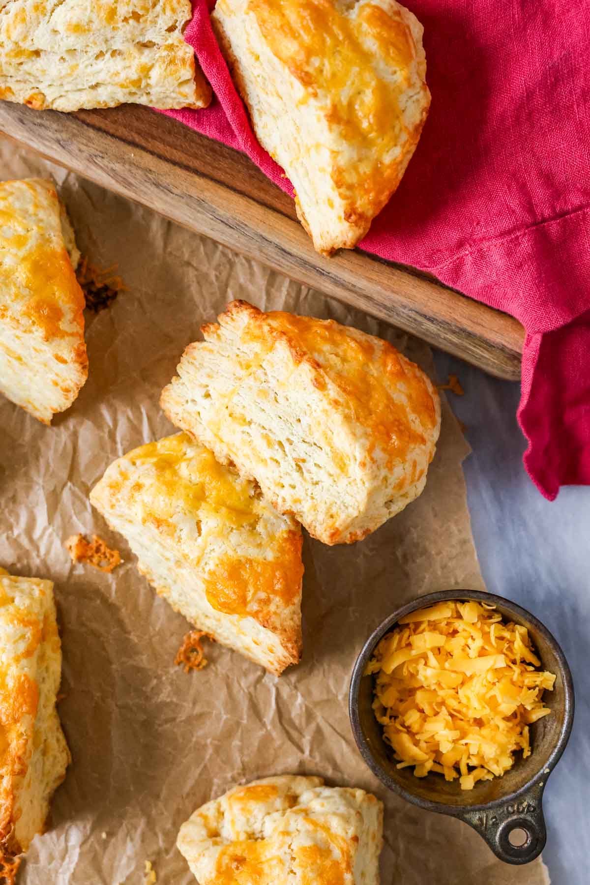 Overhead view of wedge shaped cheese scones with the top scone on its side to show flaky layers.