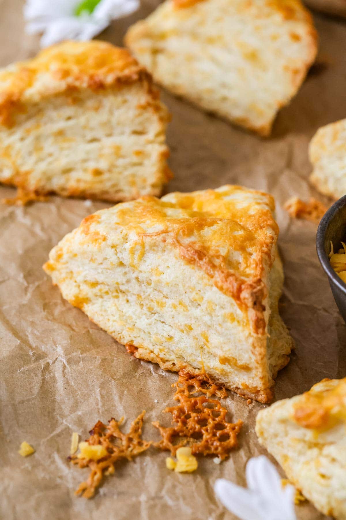 Tall, flaky scones that have been cut into wedges and topped with cheddar cheese.