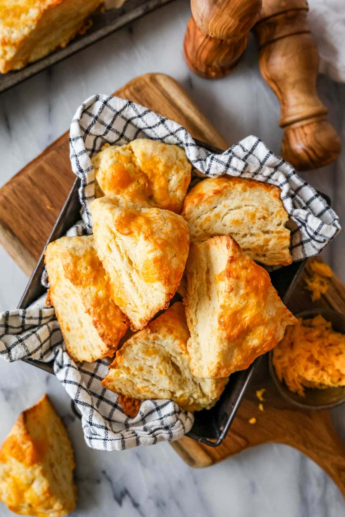 Overhead view of a basket of cheese scones that have risen tall with flaky layers.