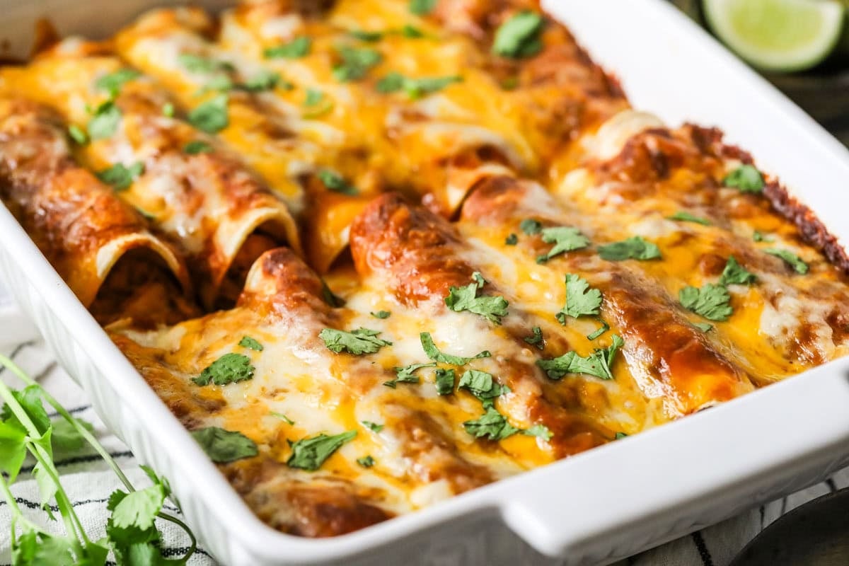 Baking dish of enchiladas topped with cilantro.