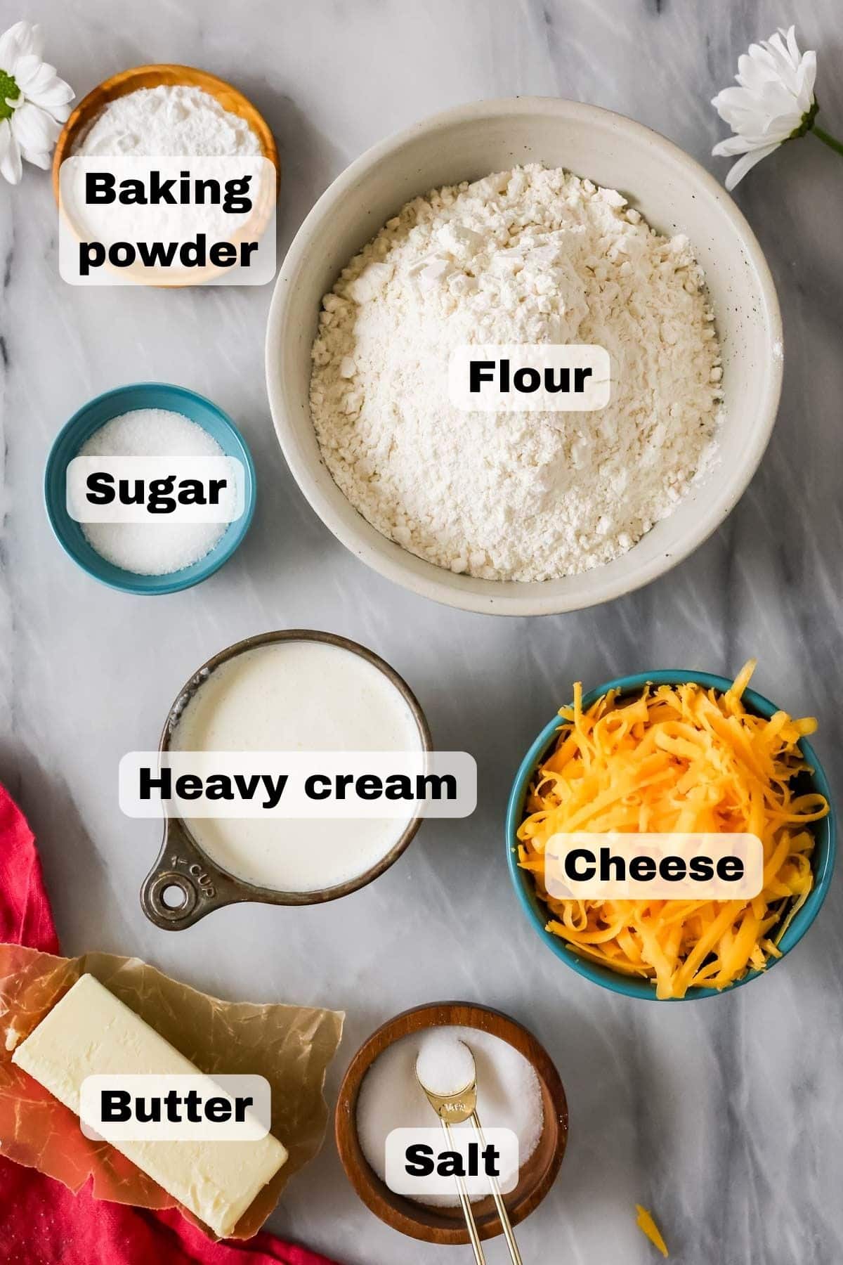Overhead view of ingredients including cheese, flour, butter, cream, and more.